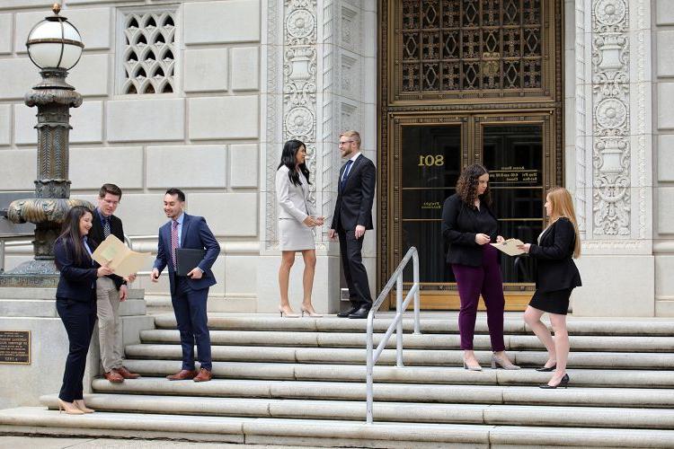 法律 students stand on the steps of the Capitol building.